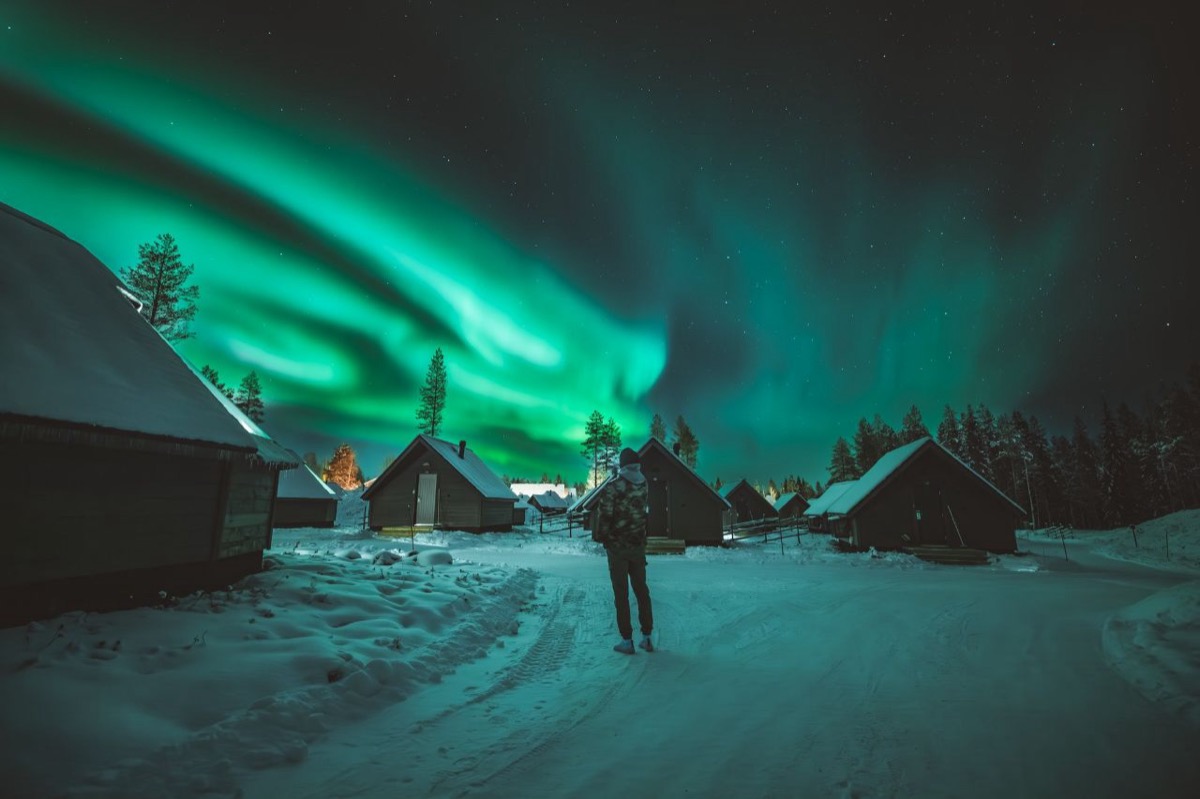 Northern Lights over a snow-covered cabin in Finnish Lapland