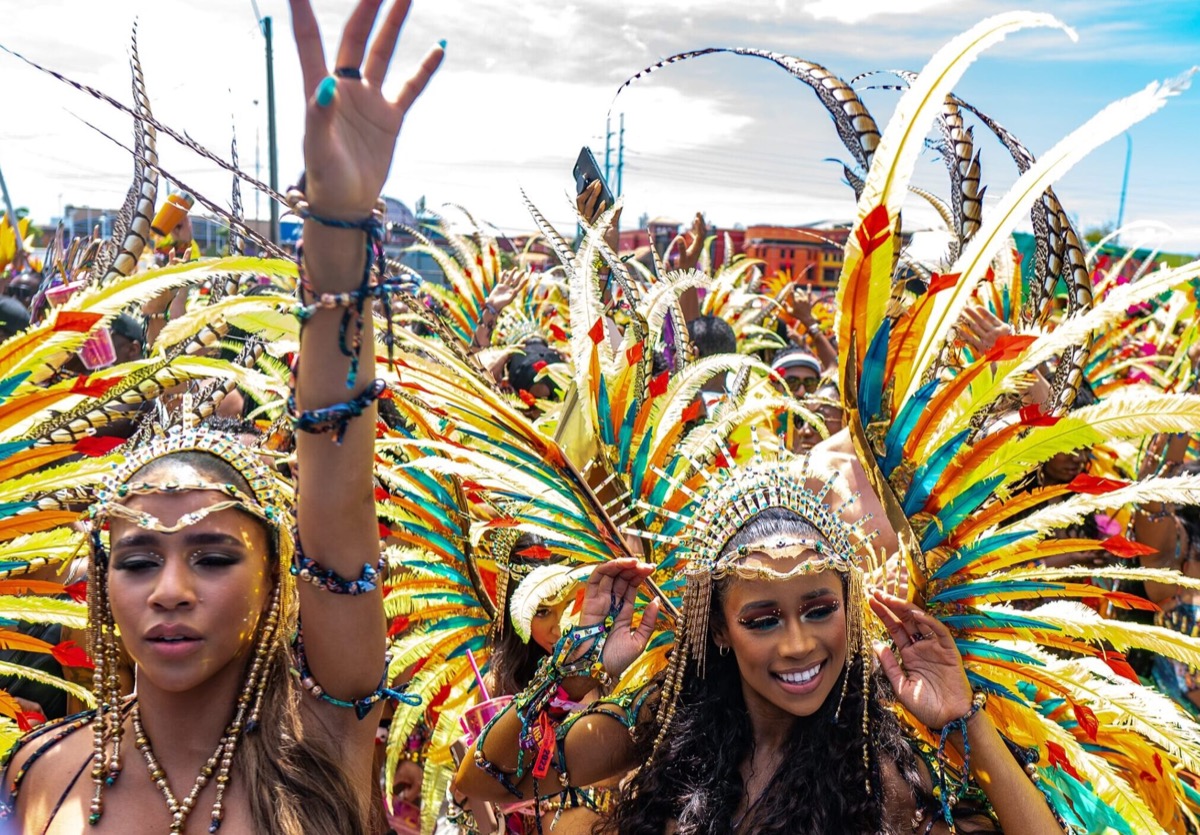 A colorful parade of people in costumes during Trinidad Carnival