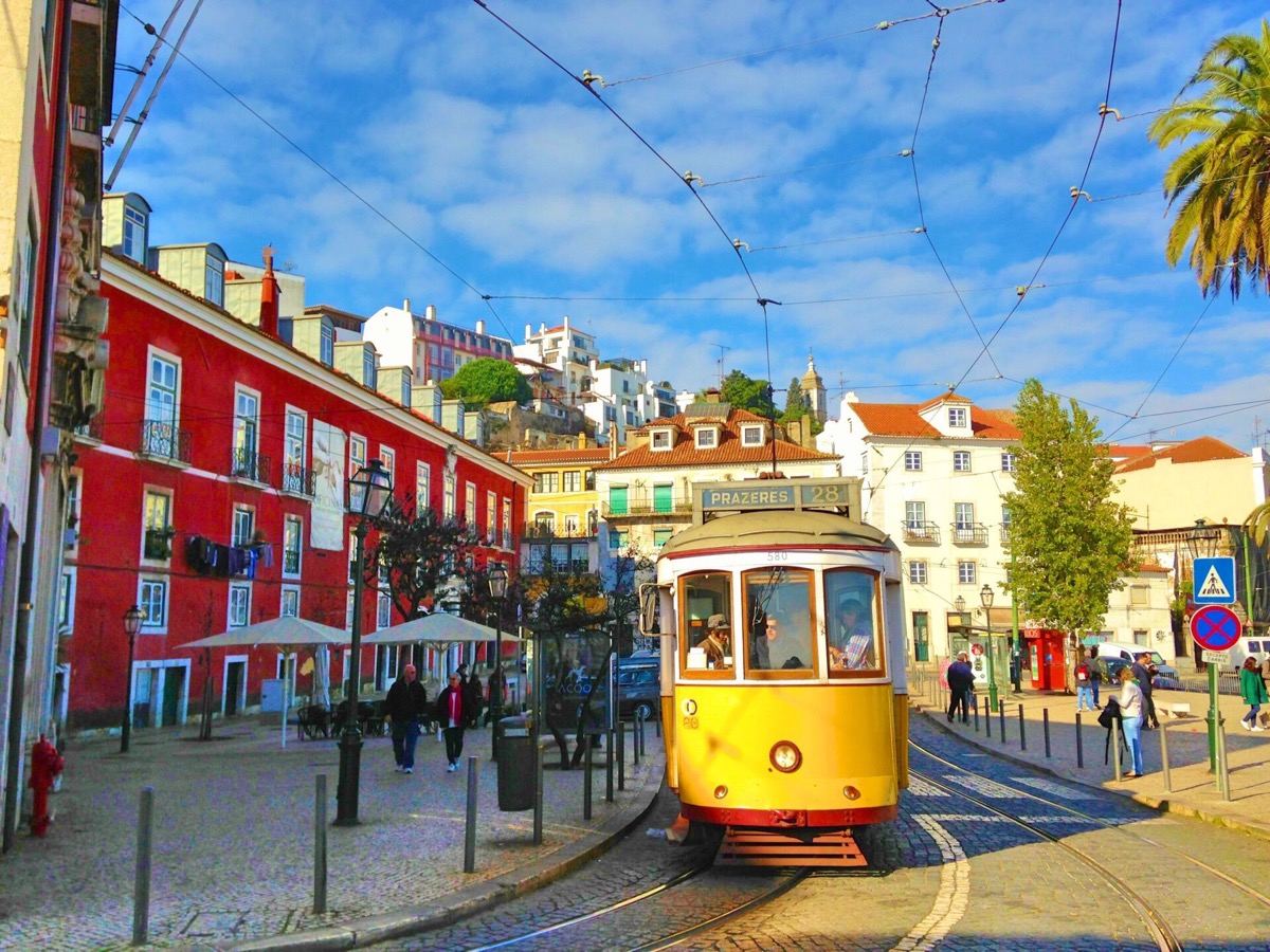 Tram 28 climbing a narrow street in Lisbon, Portugal