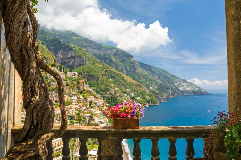 Aerial view of Amalfi Coast towns cascading down steep limestone cliffs above the deep blue Tyrrhenian Sea