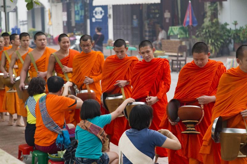 Luang Prabang Laos — saffron-robed monks during the Tak Bat alms-giving ceremony at dawn