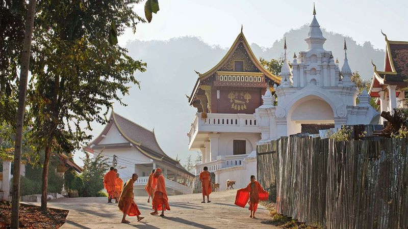 Luang Prabang — turquoise tiered pools at Kuang Si waterfall surrounded by bamboo and jungle