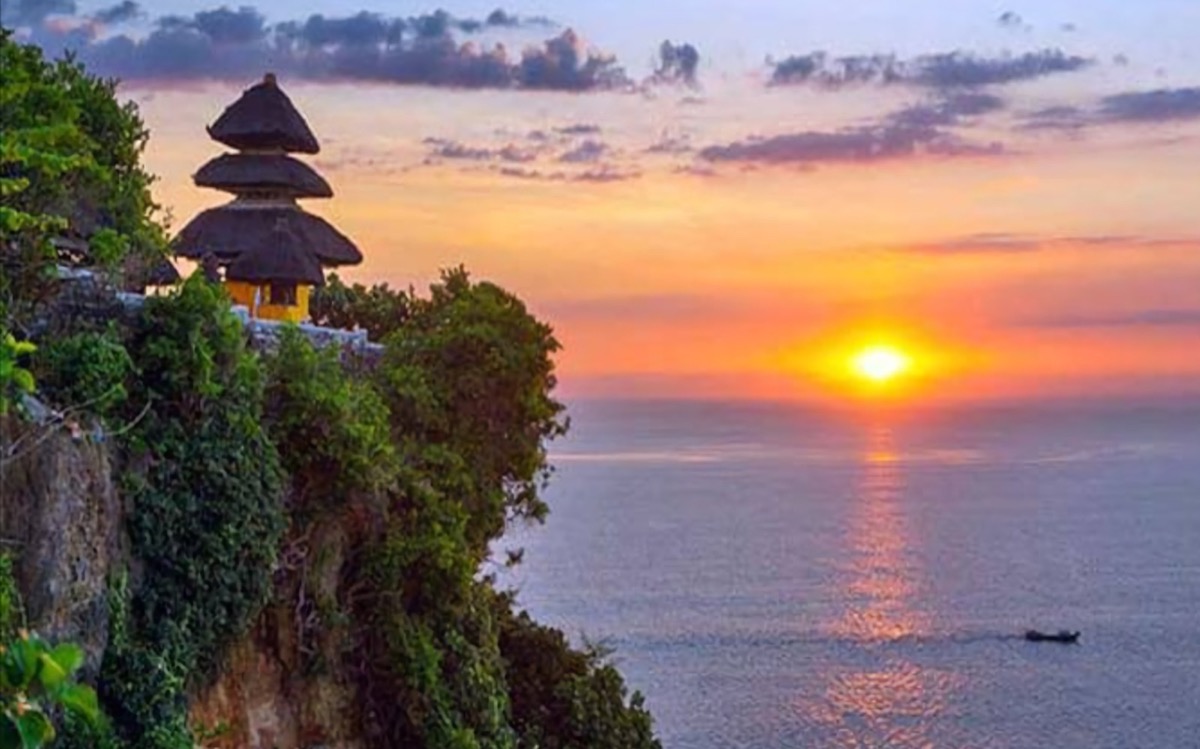 Uluwatu Temple perched on dramatic ocean cliffs in Bali at sunset