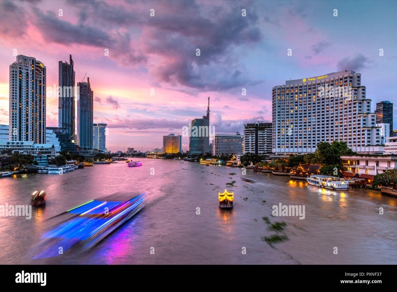 Chao Phraya River and Bangkok skyline with gilded temple spires at dusk