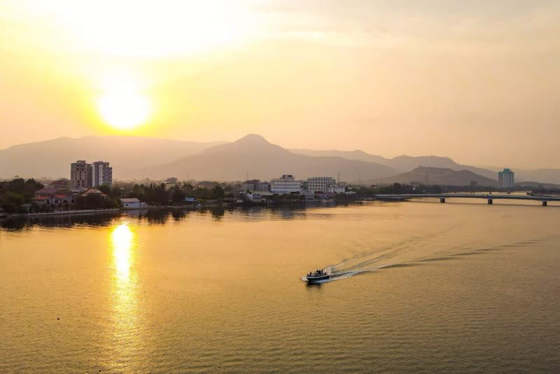 Kampot riverside town at dusk with Bokor Mountain in the background