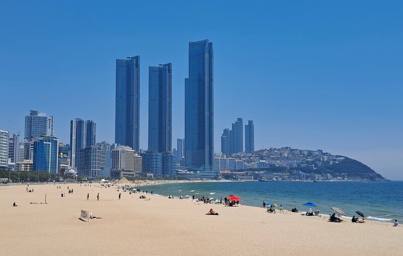 Busan Haeundae Beach coastline with city skyscrapers at dusk