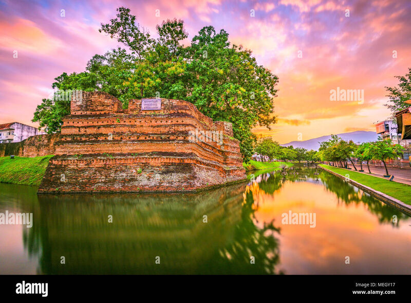 Chiang Mai old city moat at dusk, with ancient walls and temple spires reflected in the water