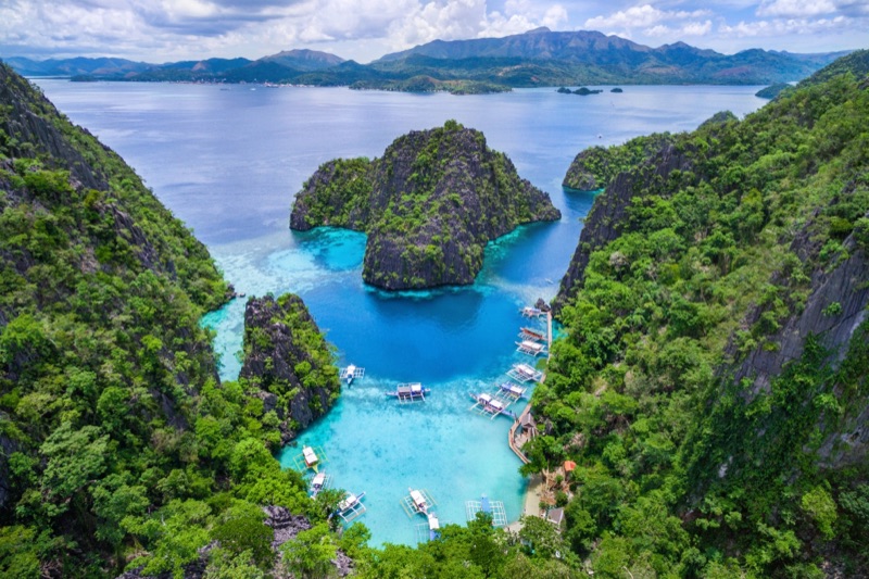 Kayangan Lake in Coron, Palawan — crystal-clear jade-green water surrounded by dramatic limestone cliffs