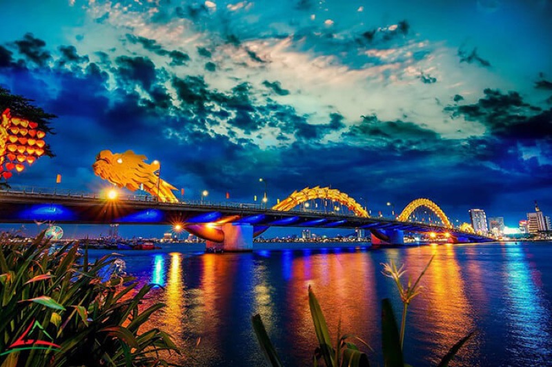Da Nang Dragon Bridge spanning the Han River at night, with fire-breathing dragon sculpture illuminated against the sky