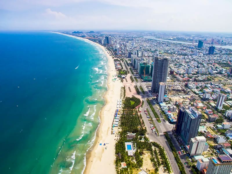 My Khe Beach Da Nang Vietnam with turquoise water, white sand and the city skyline behind