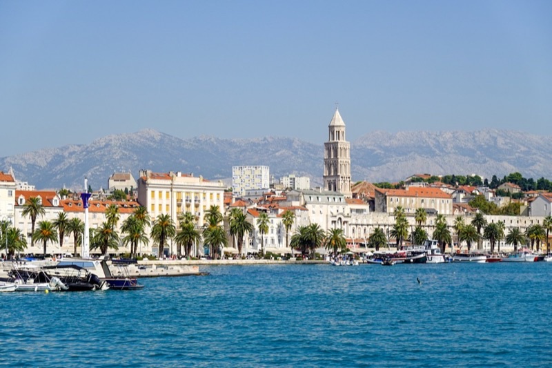 Split’s waterfront promenade and harbor with palm trees and the old town of Split, Croatia