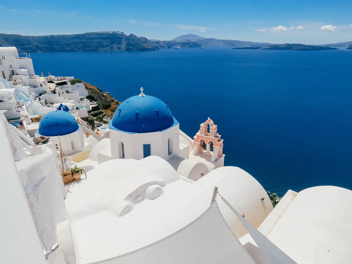 Santorini, Greece — iconic white-washed buildings and blue domes overlooking the Aegean Sea