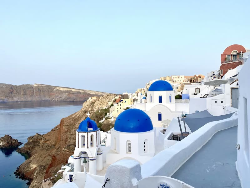 Santorini, Greece — iconic whitewashed buildings and blue domes above turquoise Aegean waters