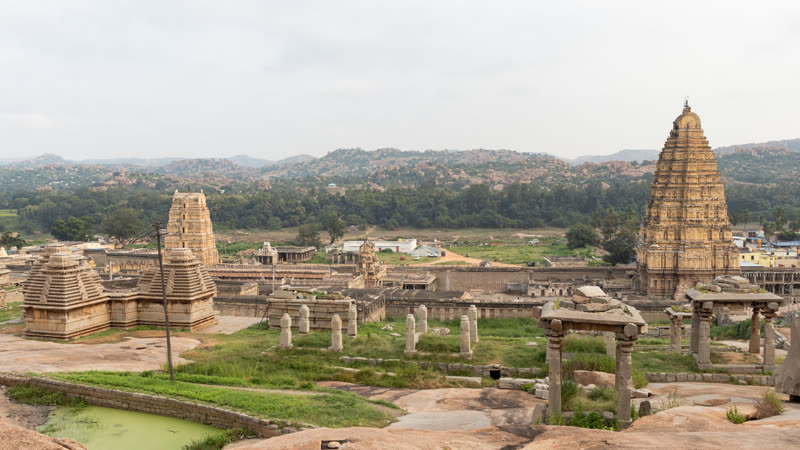 Virupaksha Temple in Hampi — the towering 15th-century Dravidian gopuram rising above the ruins of the Vijayanagara Empire, framed by Karnataka's granite boulder landscape