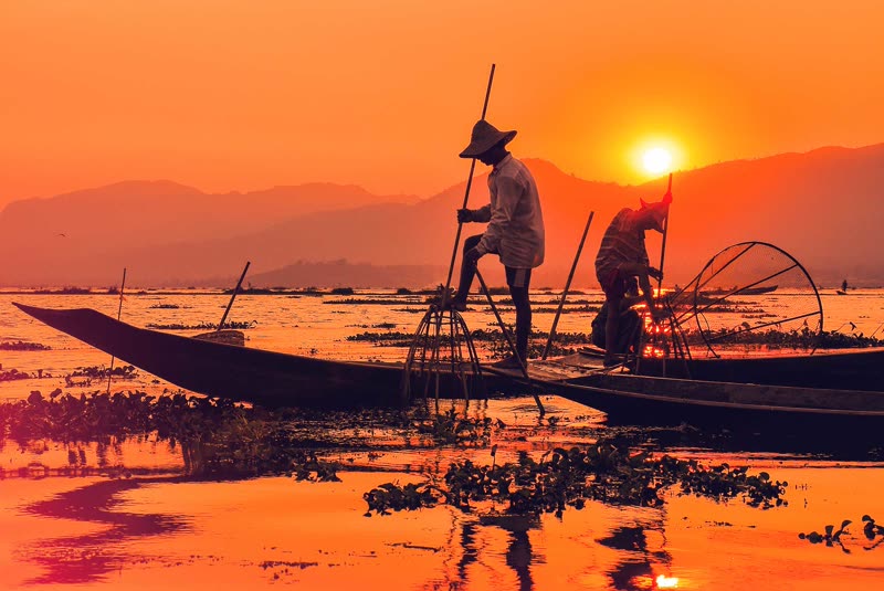 Inle Lake Myanmar traditional fishermen at sunrise with leg-rowing technique