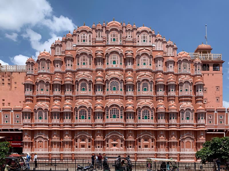 Hawa Mahal in Jaipur — the iconic pink sandstone Palace of Winds with its 953 small windows and elaborate honeycomb facade, photographed from street level