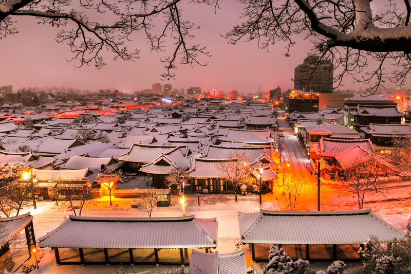 Jeonju Hanok Village at dawn — traditional Korean wooden houses with curved tile roofs stretching across the neighborhood