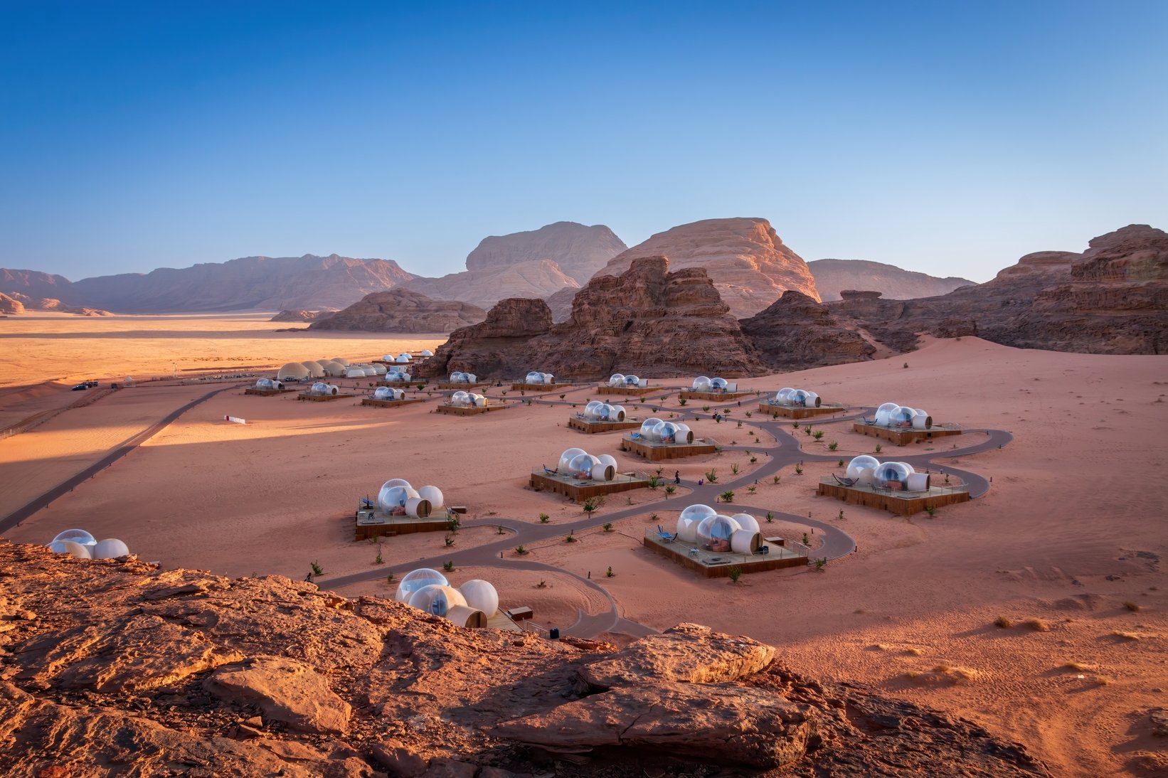 Wadi Rum desert landscape in Jordan — vast red sand dunes and dramatic sandstone cliffs under a wide open sky