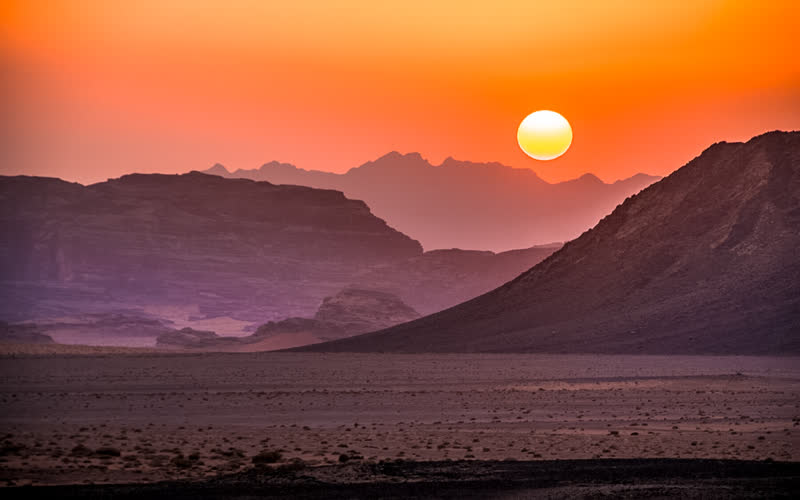 Wadi Rum desert at sunset, Jordan — red sand and sandstone mountains