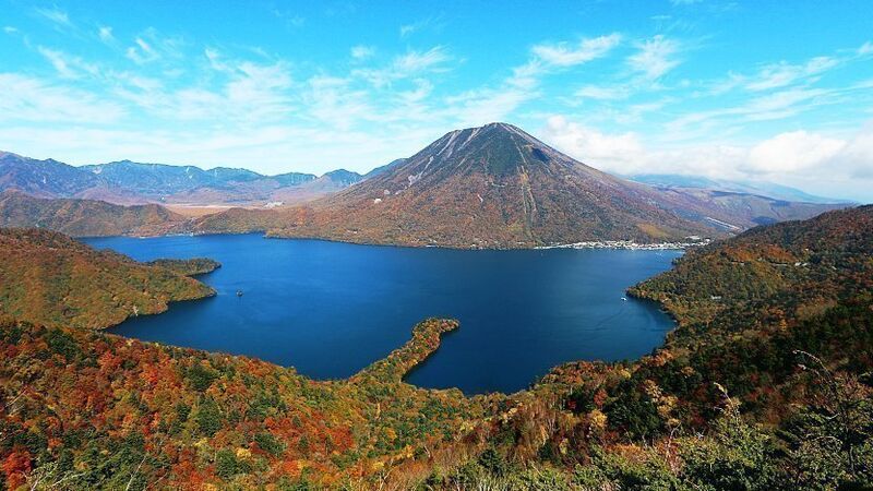 Lake Chuzenji at Oku-Nikko with autumn foliage reflecting in the calm water, Japan
