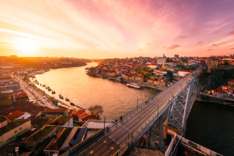 The iconic Dom Luís I double-deck iron bridge spanning the Douro River at sunset, Porto Portugal