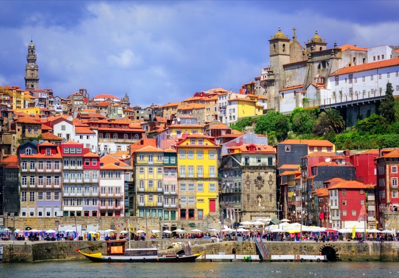 Porto's Ribeira district along the Douro River with colorful medieval townhouses and traditional wooden boats