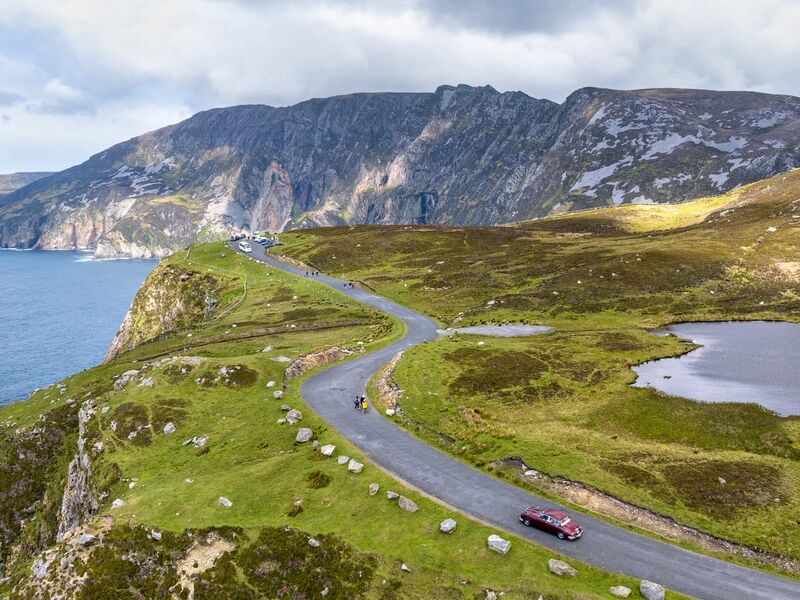 Ireland's Wild Atlantic Way coastline in Connemara — dramatic cliffs, emerald fields, and rolling Atlantic waves