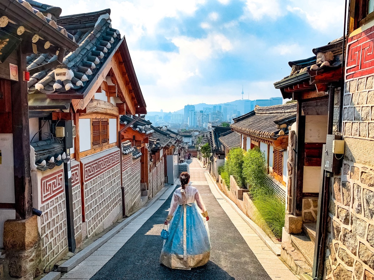 Bukchon Hanok Village in Seoul — traditional Korean hanok houses with the city skyline behind