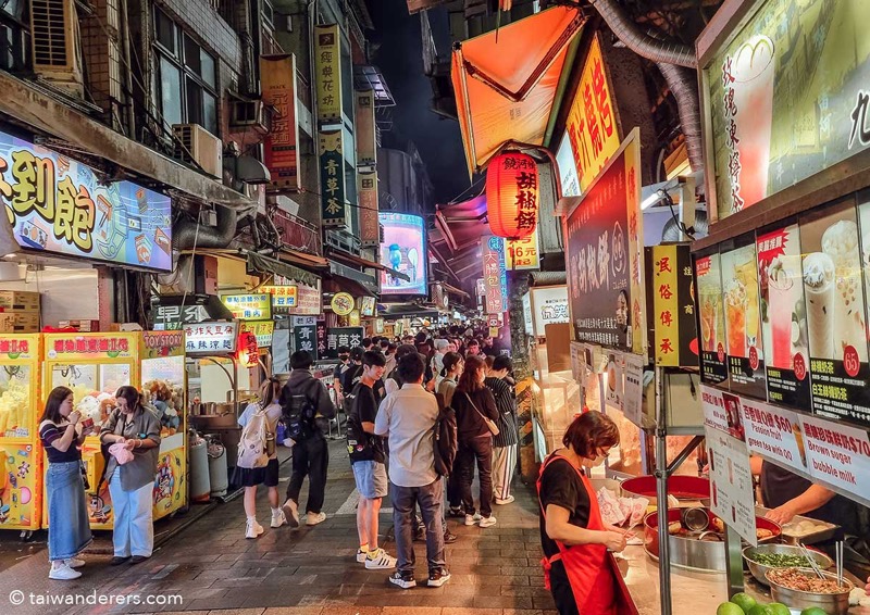 Taipei night market food stalls with crowds and street food