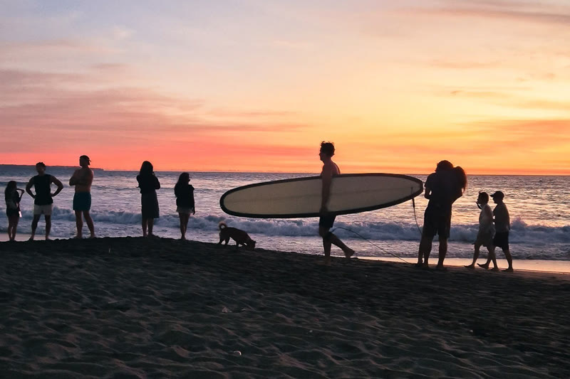 Surfing at Batu Bolong beach in Canggu, Bali — surfers riding waves at sunset