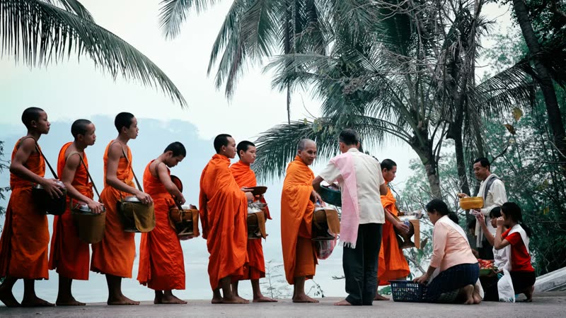 Luang Prabang — monks in saffron robes during the morning alms-giving ceremony on Sisavangvong Road