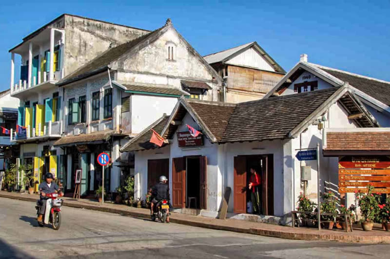 Luang Prabang old town street — French colonial buildings lining the main street with temples visible in background