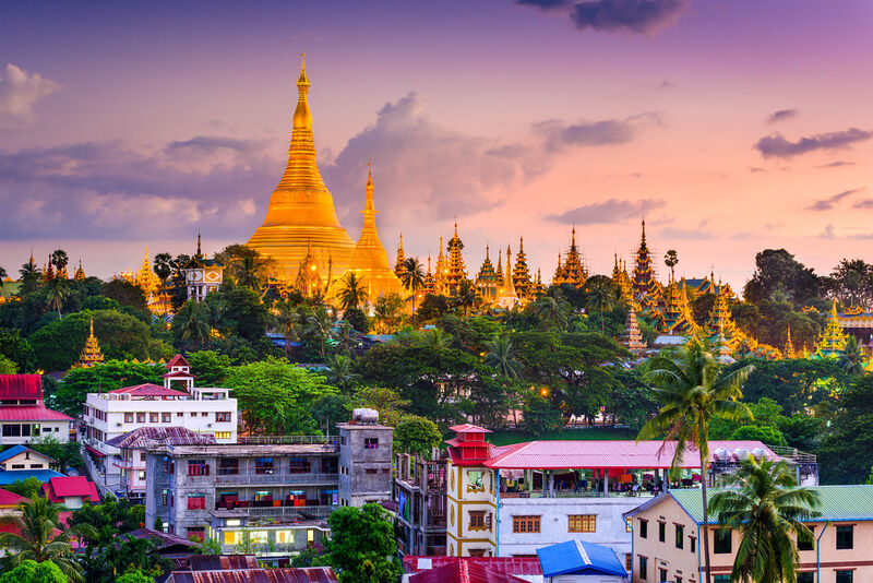 Yangon Myanmar — Shwedagon Pagoda at dusk with golden stupa reflecting light above the city