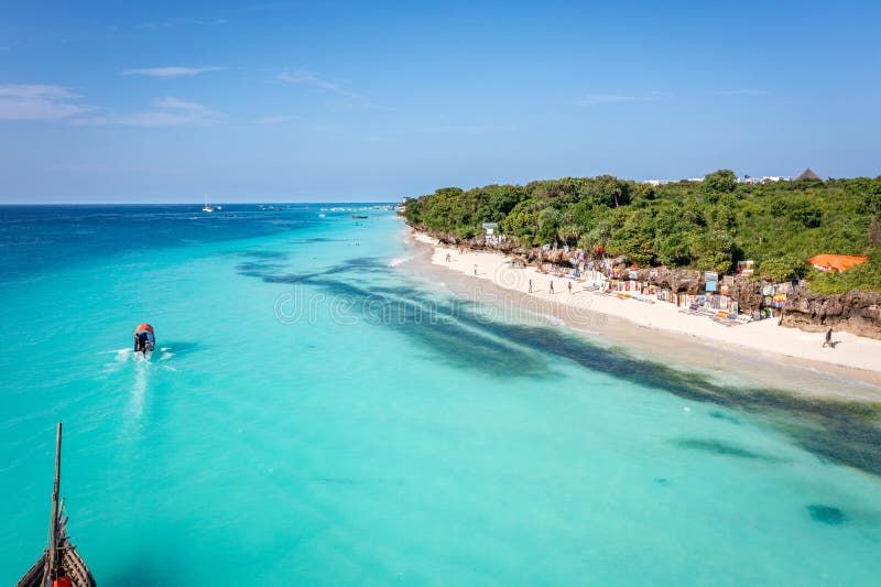 Nungwi Beach in Zanzibar with turquoise water, white sand and traditional dhow boats