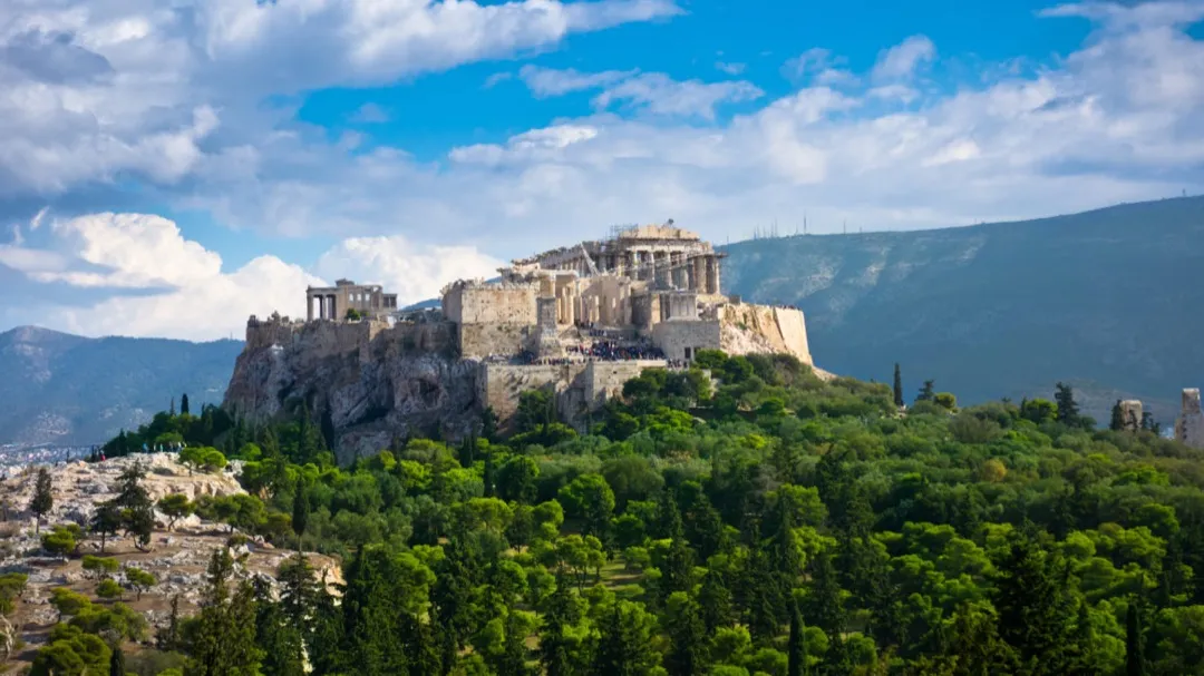 The ancient Parthenon stands proudly atop the Acropolis, glowing under the warm Mediterranean sunset in Athens.