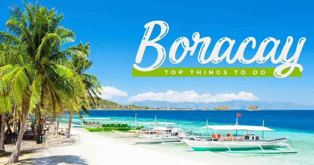 A vibrant sunset paints the sky over Boracay's White Beach, with traditional paraw sailboats silhouetted against the horizon.