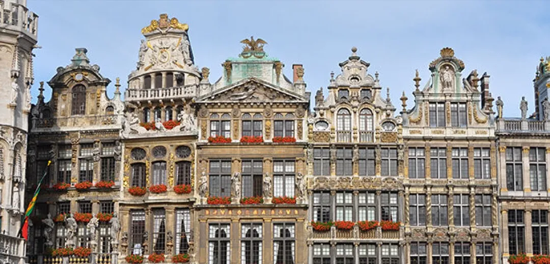 Ornate golden guildhalls encircling the bustling cobblestone Grand Place at dusk, reflecting historic grandeur.
