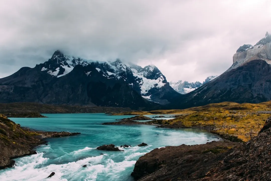 A majestic view of the granite towers of Torres del Paine rising dramatically above turquoise glacial lakes in Chilean Patagonia.