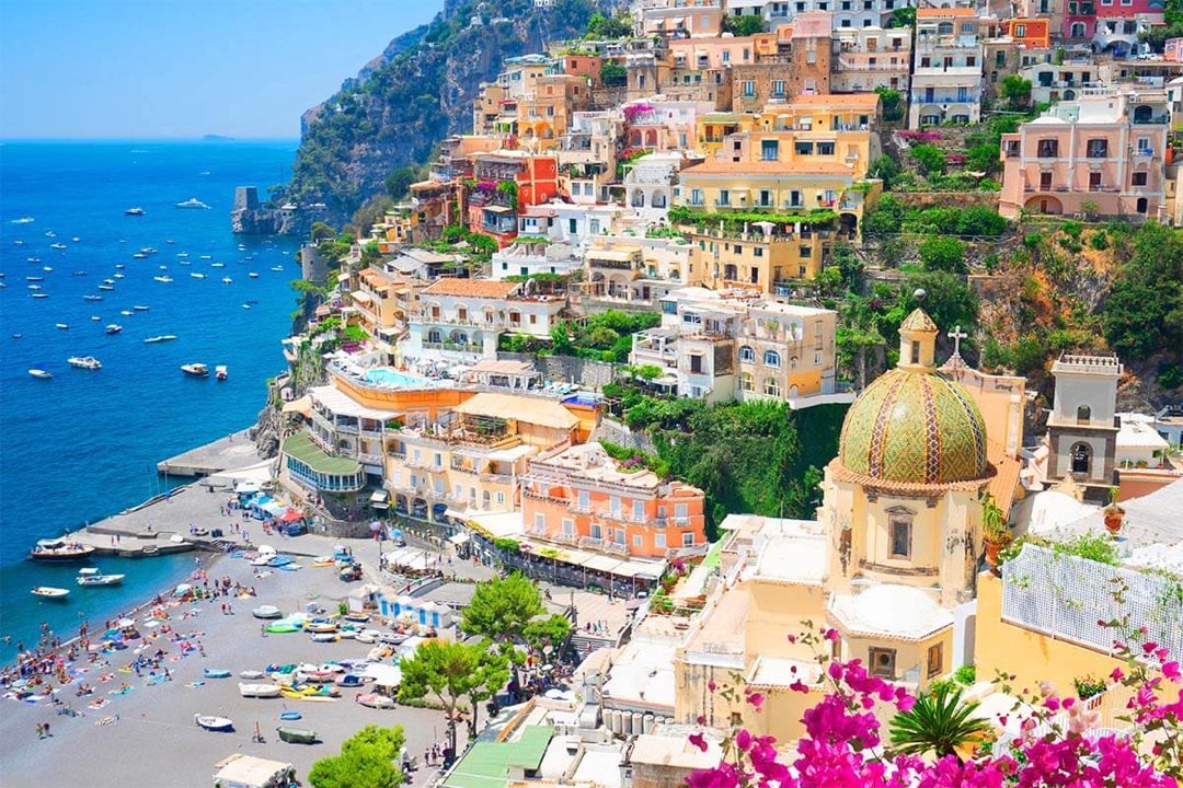 Panoramic view of Naples city sprawled around the curving bay, with Mount Vesuvius majestically looming in the hazy distance.