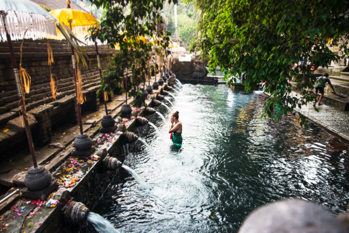 Tirta Empul holy water temple with sacred bathing pools and golden ceremonial umbrellas, Bali