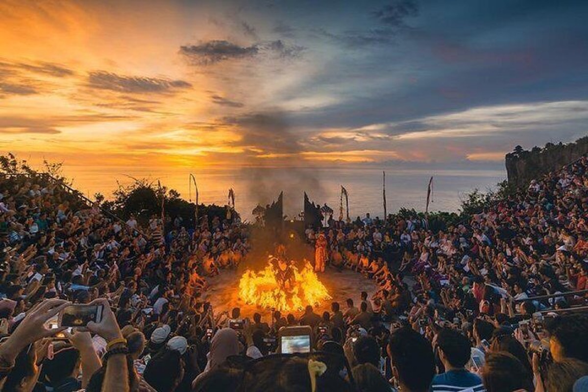 Kecak fire dance performance at Uluwatu Temple with golden ocean sunset backdrop, Bali