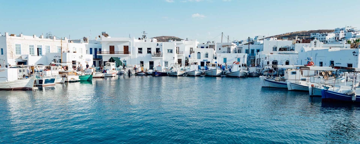 Naoussa fishing harbor Paros Greece with white Cycladic buildings
