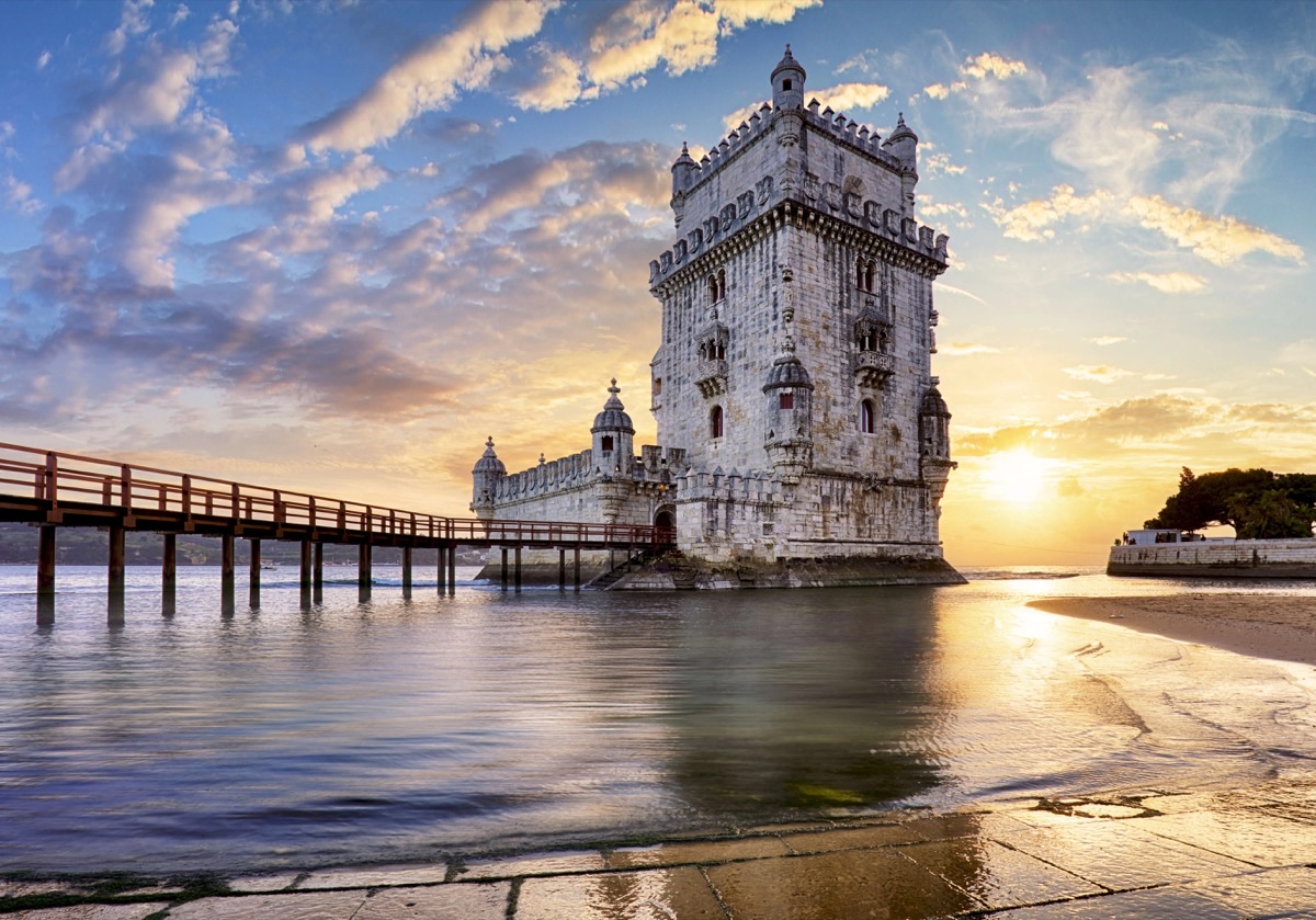 Belém Tower at golden sunset with reflections on the Tagus River, Lisbon