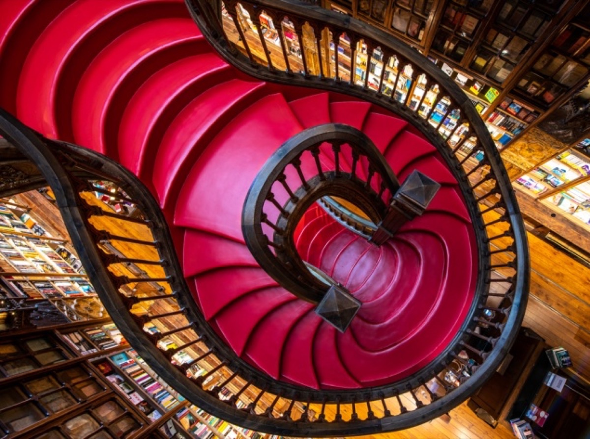 Top-down view of the iconic crimson spiral staircase at Livraria Lello bookstore, Porto