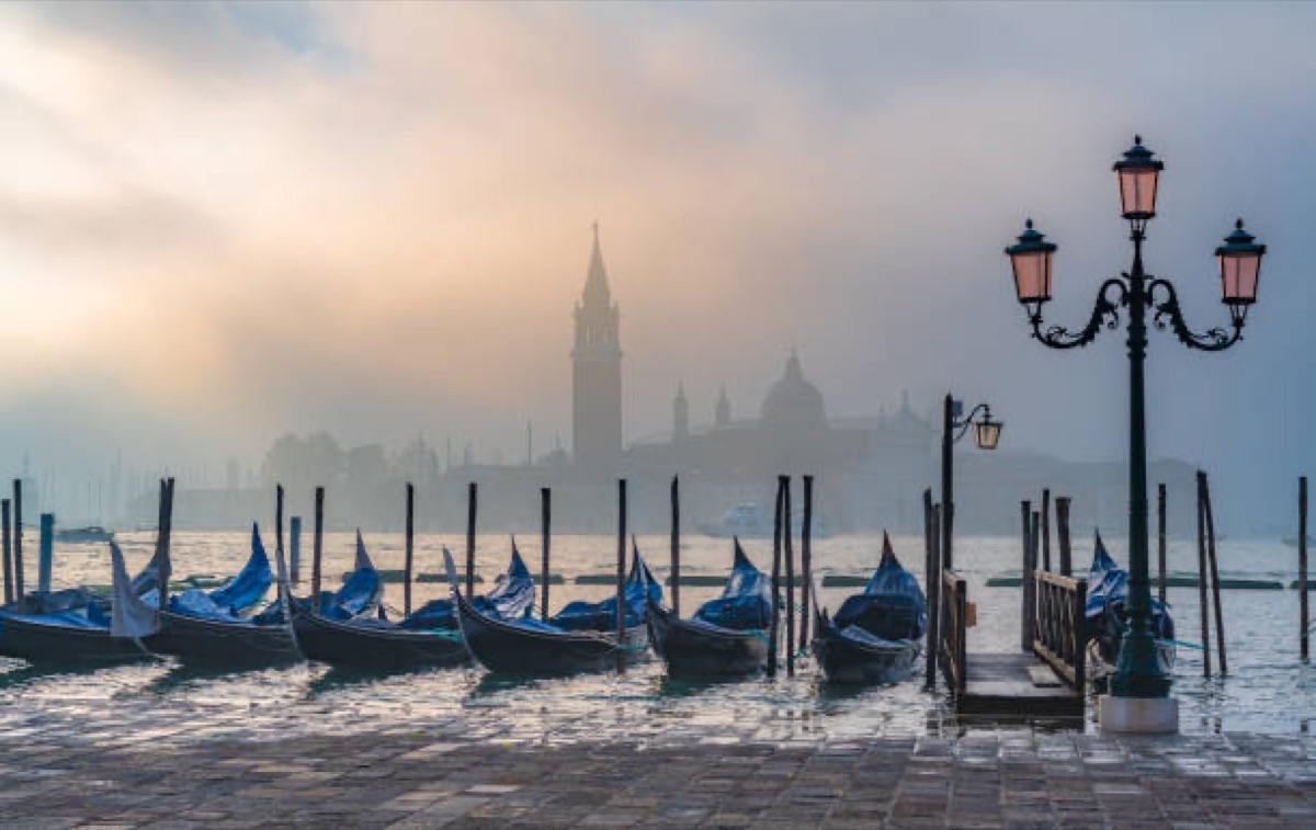 Venice lagoon in morning mist with gondola, Italy