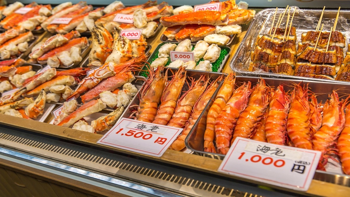 Fresh seafood displays and colorful stalls at Kuromon Ichiba Market, Osaka