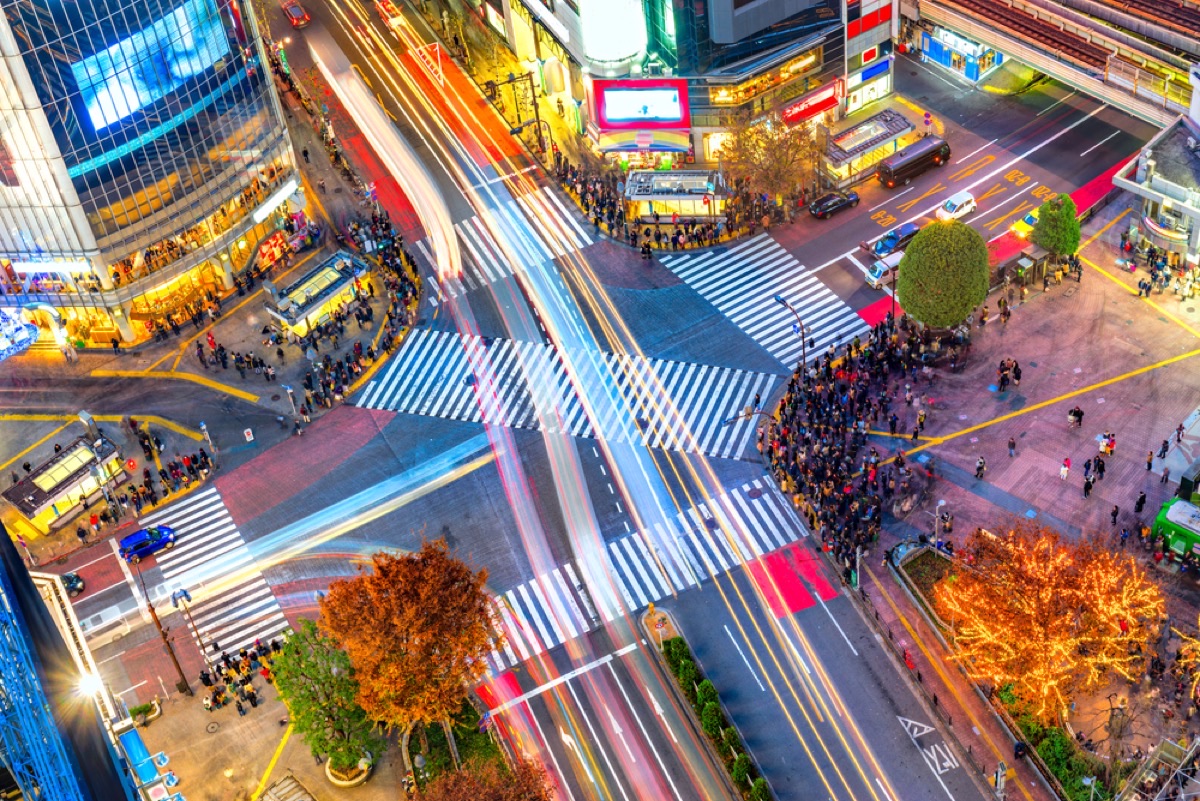 Aerial view of Shibuya Crossing with light trails and neon signs at night, Tokyo