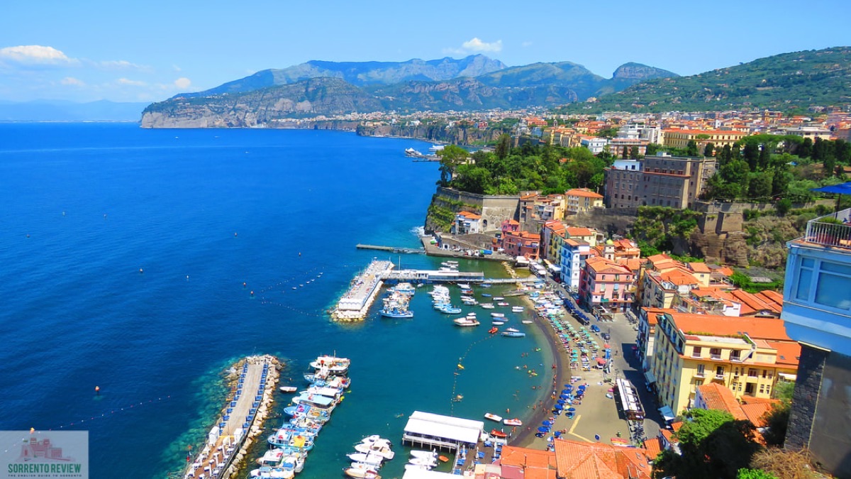Marina Grande harbor in Sorrento with colorful boats and cliffside village, Amalfi Coast Italy