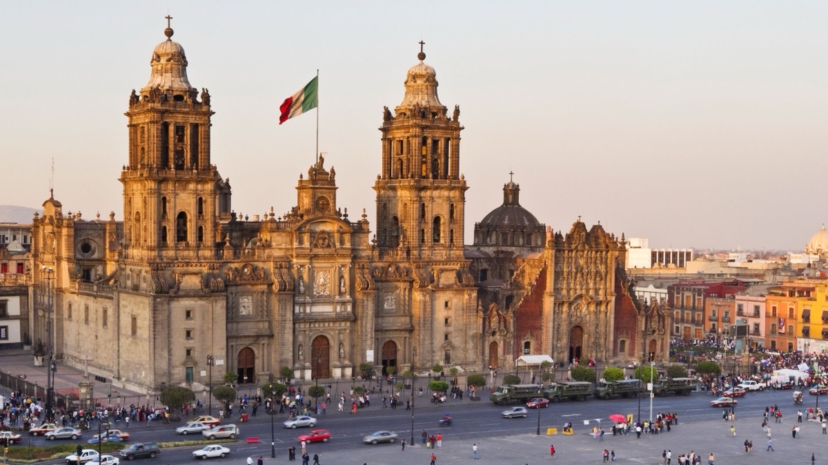 Mexico City Metropolitan Cathedral at golden hour with Mexican flag at the Zocalo