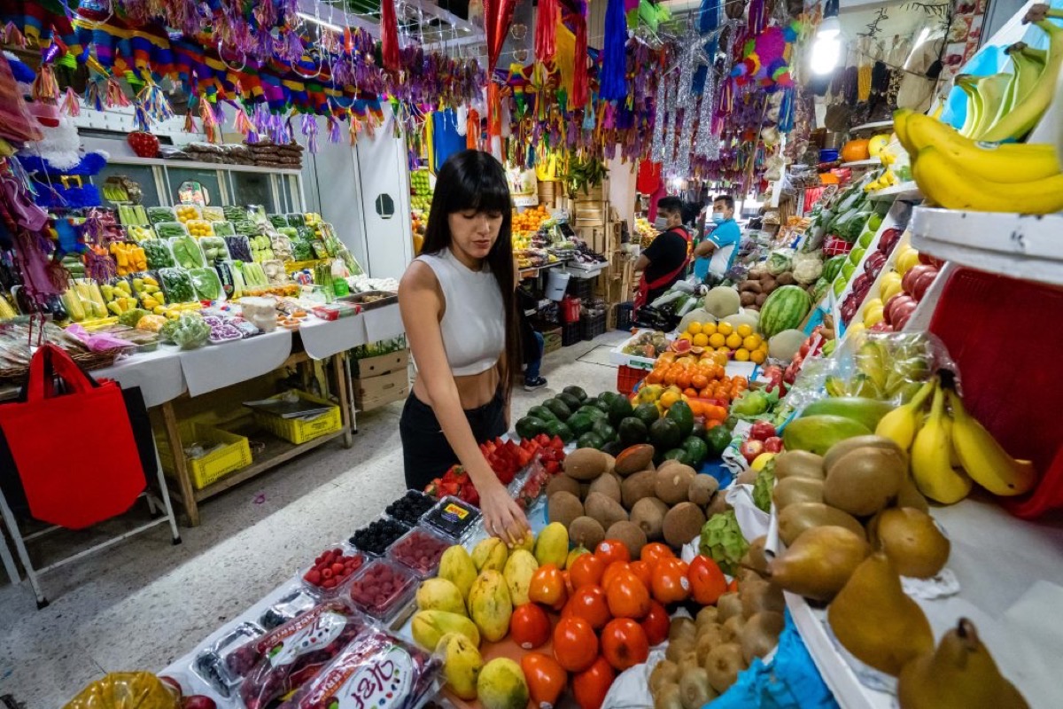 Colorful fruit stalls and piñata decorations at Mercado de San Juan food market in Mexico City
